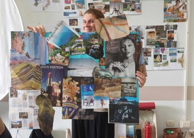 Ragazza sorridente mostra una grande vision board di immagini, parole e luoghi realizzata in un laboratorio creativo